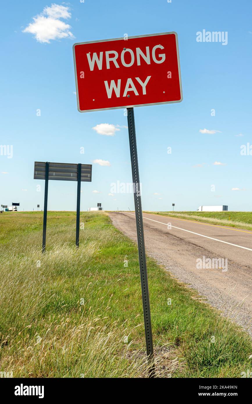 Bright red road sign reads Wrong Way. Stock Photo