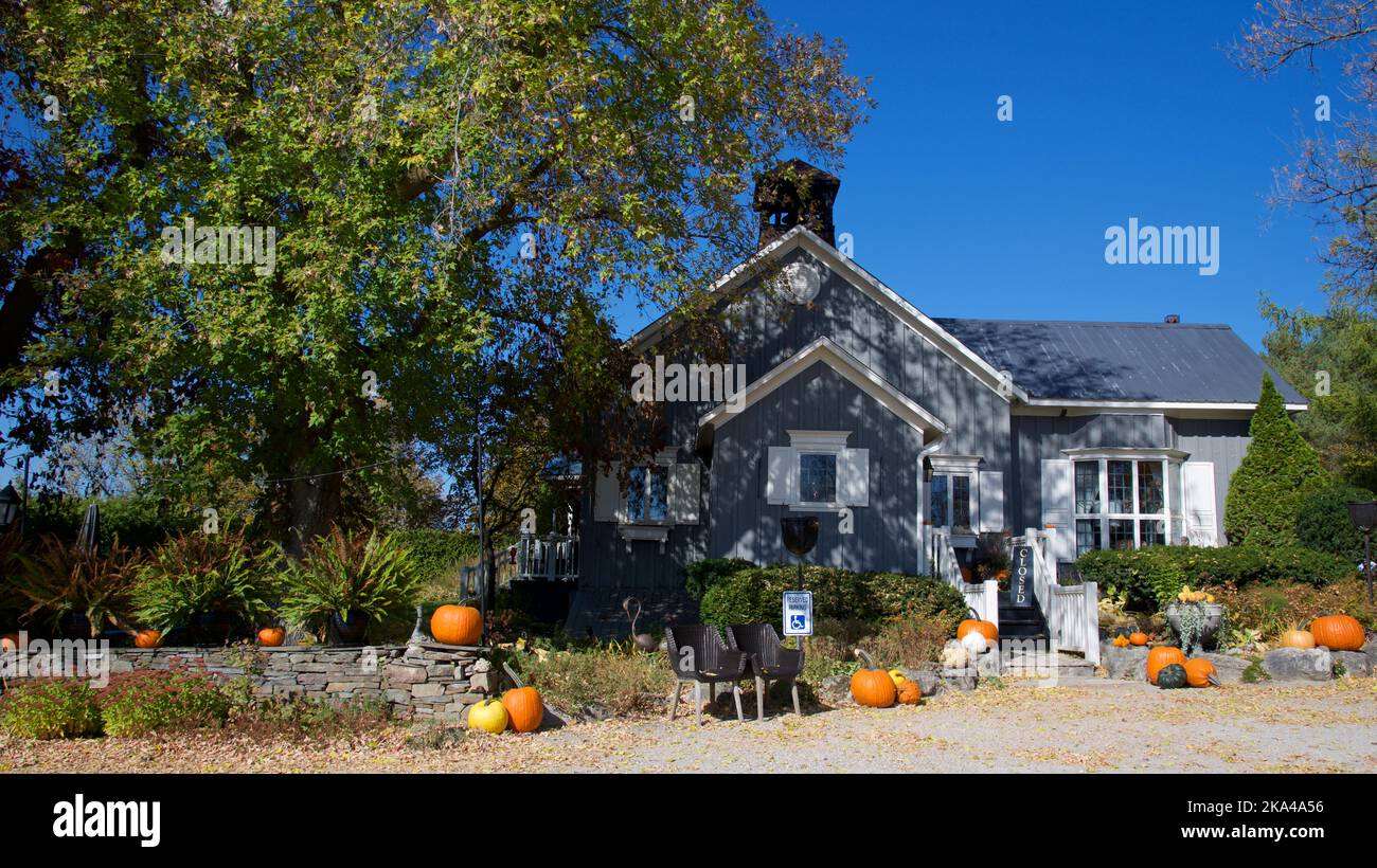 Violet Hill, Ontario / Canada - 10/10/2018: Pumpkin decoration on a Victorian-style house with the stone-material fence. Stock Photo