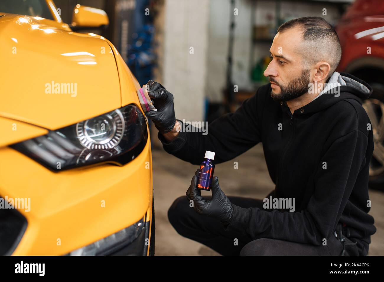 Skillful and professional male auto service worker polishing and