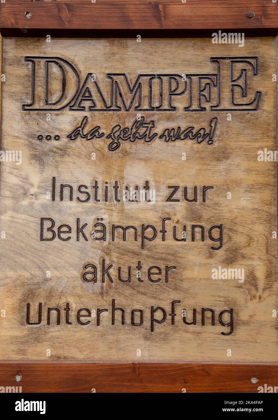 A vertical closeup of a wooden board with inscription Institute for  Combating Acute Underhops, Dampfe Stock Photo - Alamy