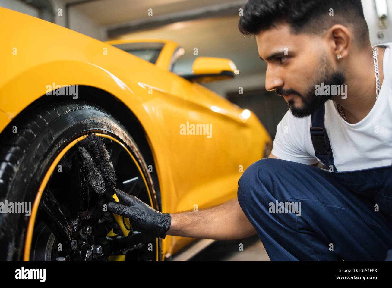 Professional male worker in overalls and black protective gloves ...