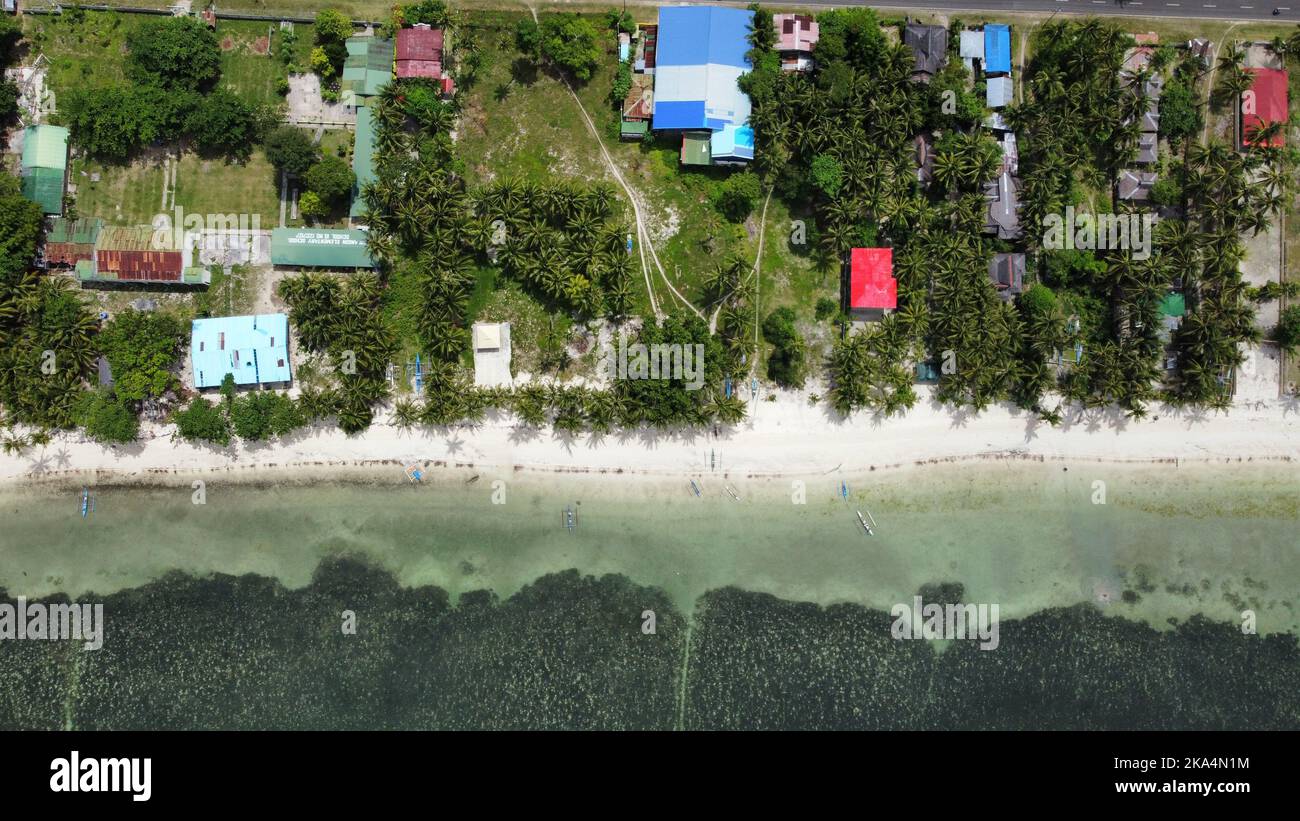 An aerial drone shot of Solangon, San Juan, Siquijor in Philippines and the sandy beach of the ocean Stock Photo