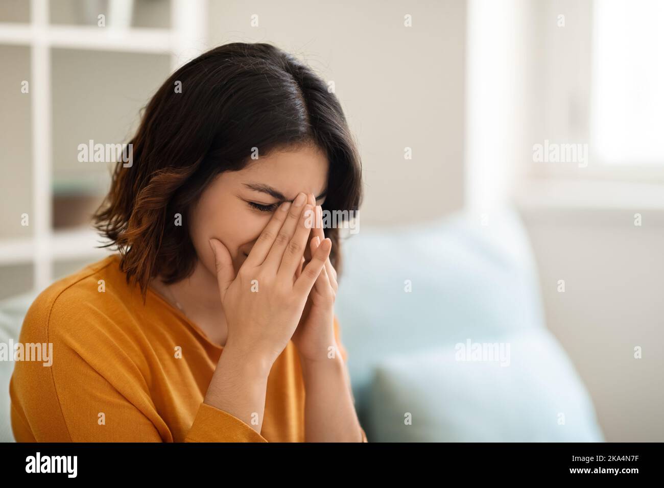 Depression Concept. Portrait Of Young Arab Woman Crying While Sitting At Home Stock Photo