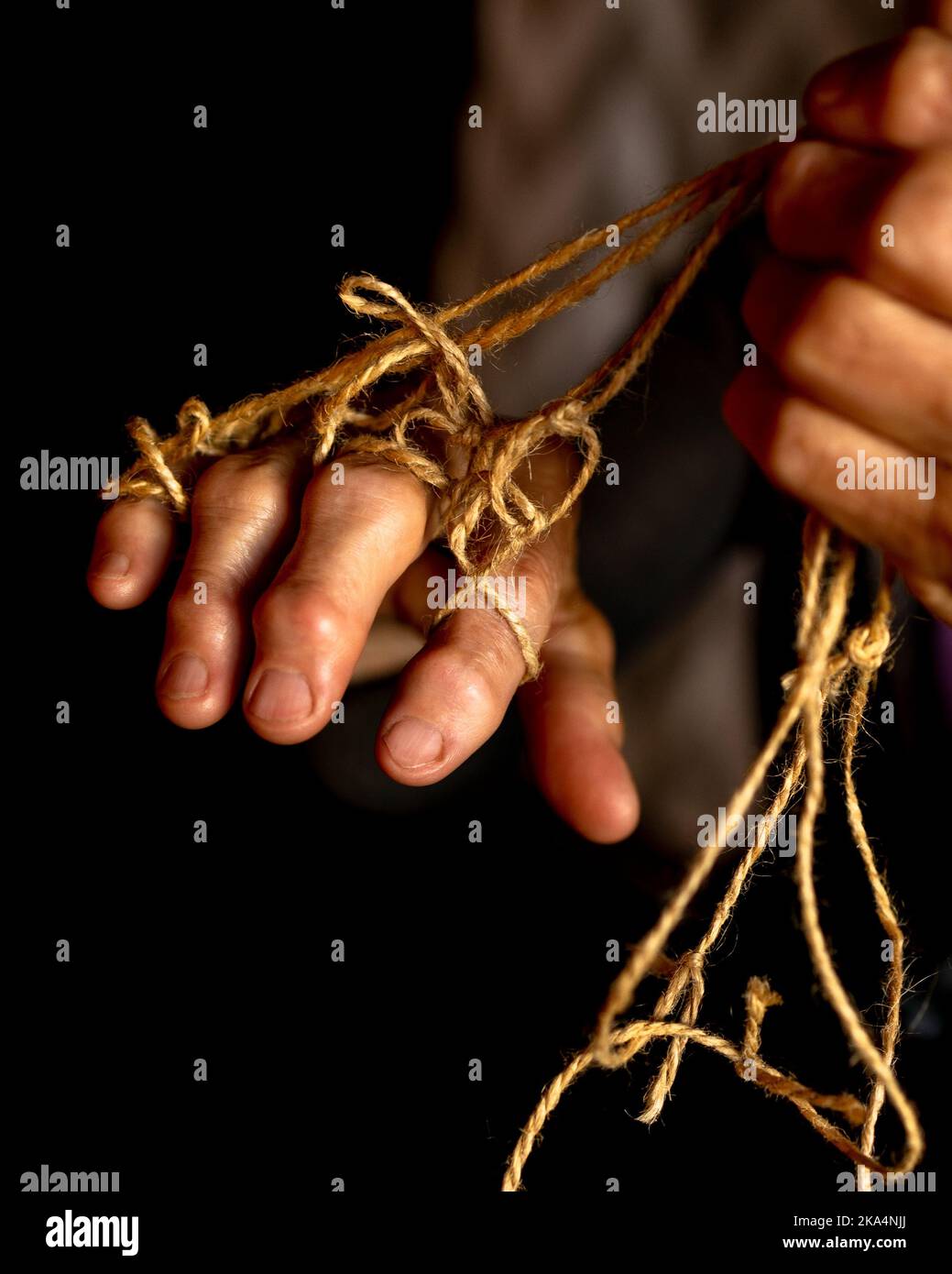 Hands of old woman with polyarthritis disease. Canvas strings on fingers of elderly lady, puppets. High quality photo Stock Photo