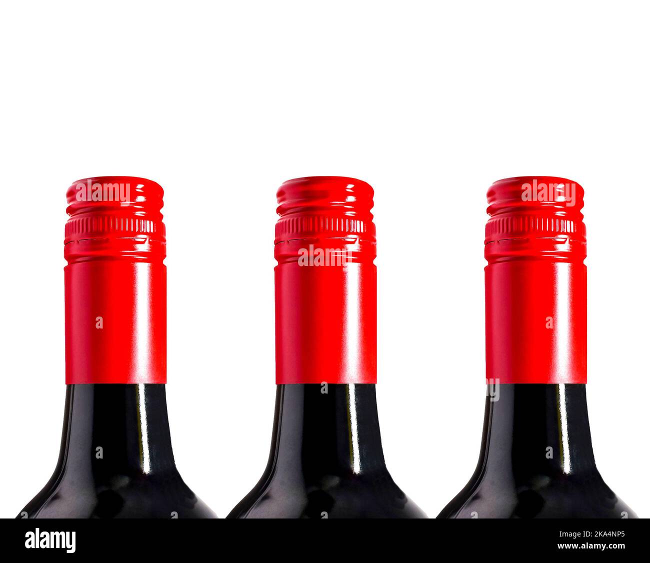 Tops of unbranded red wine bottles in a row, isolated on a plain white background. No people. Copy space. Stock Photo