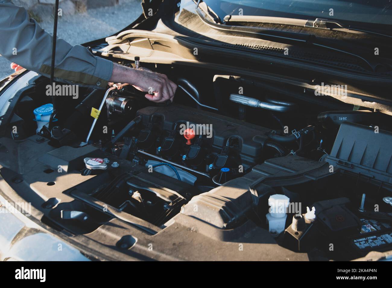 Car with hood open and a person, older man, checking or working on the