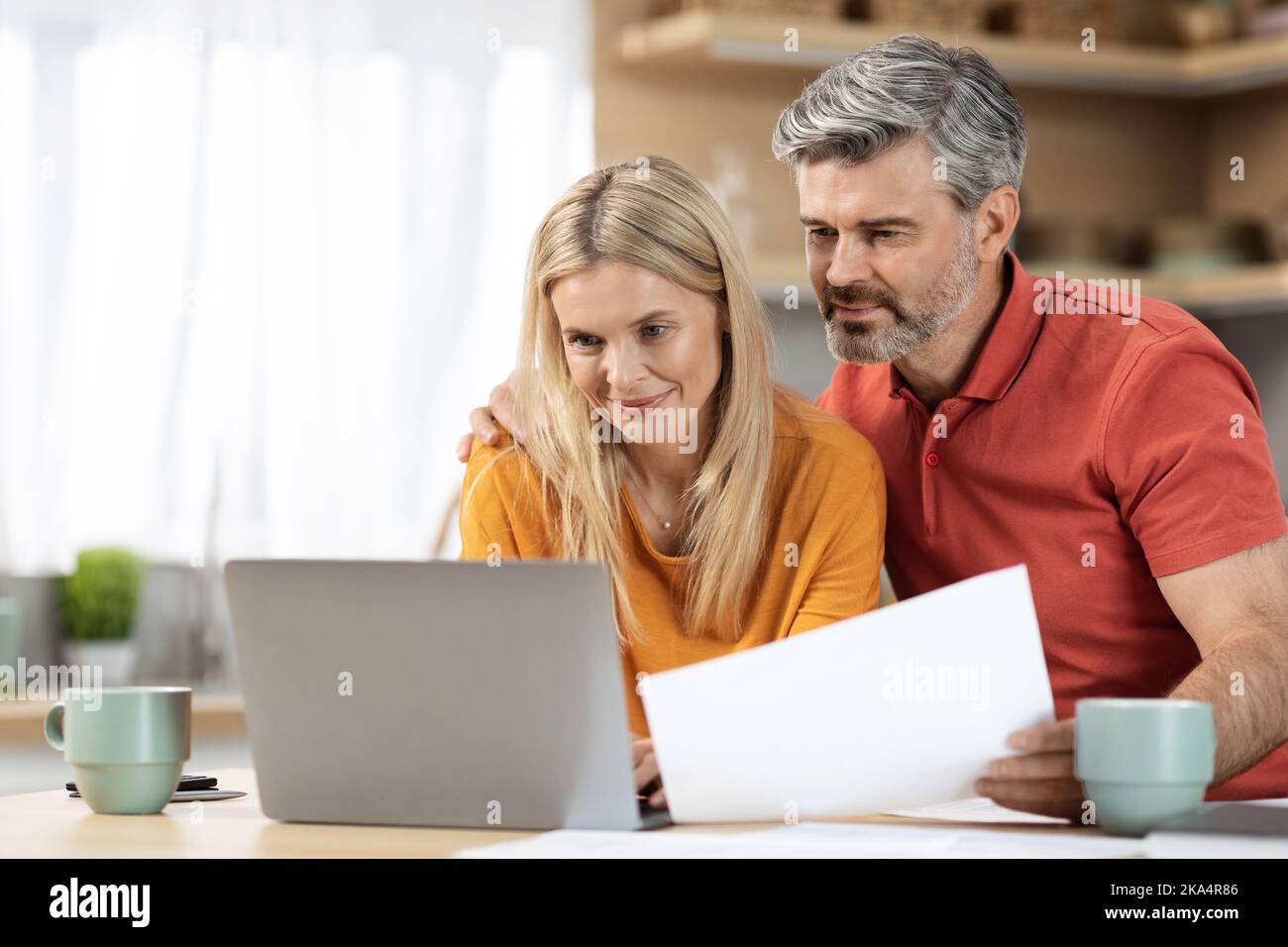 Attractive middle aged spouses working from home Stock Photo