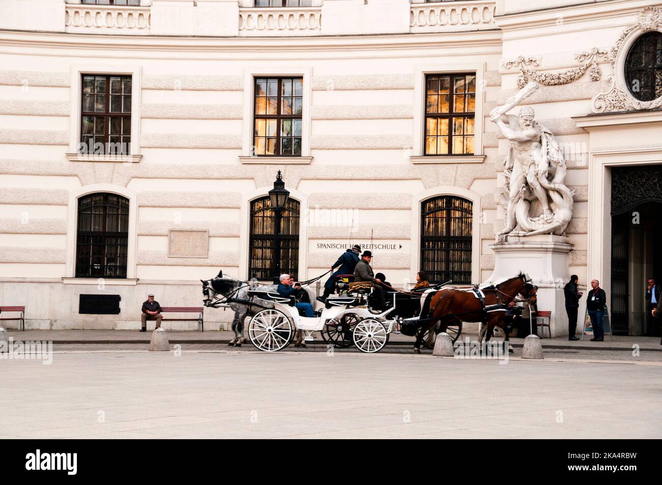 Viennese Fiakers and a gigantic sculpture of Hercules slaying Hydra at the gate to Hofburg Palace. Stock Photo