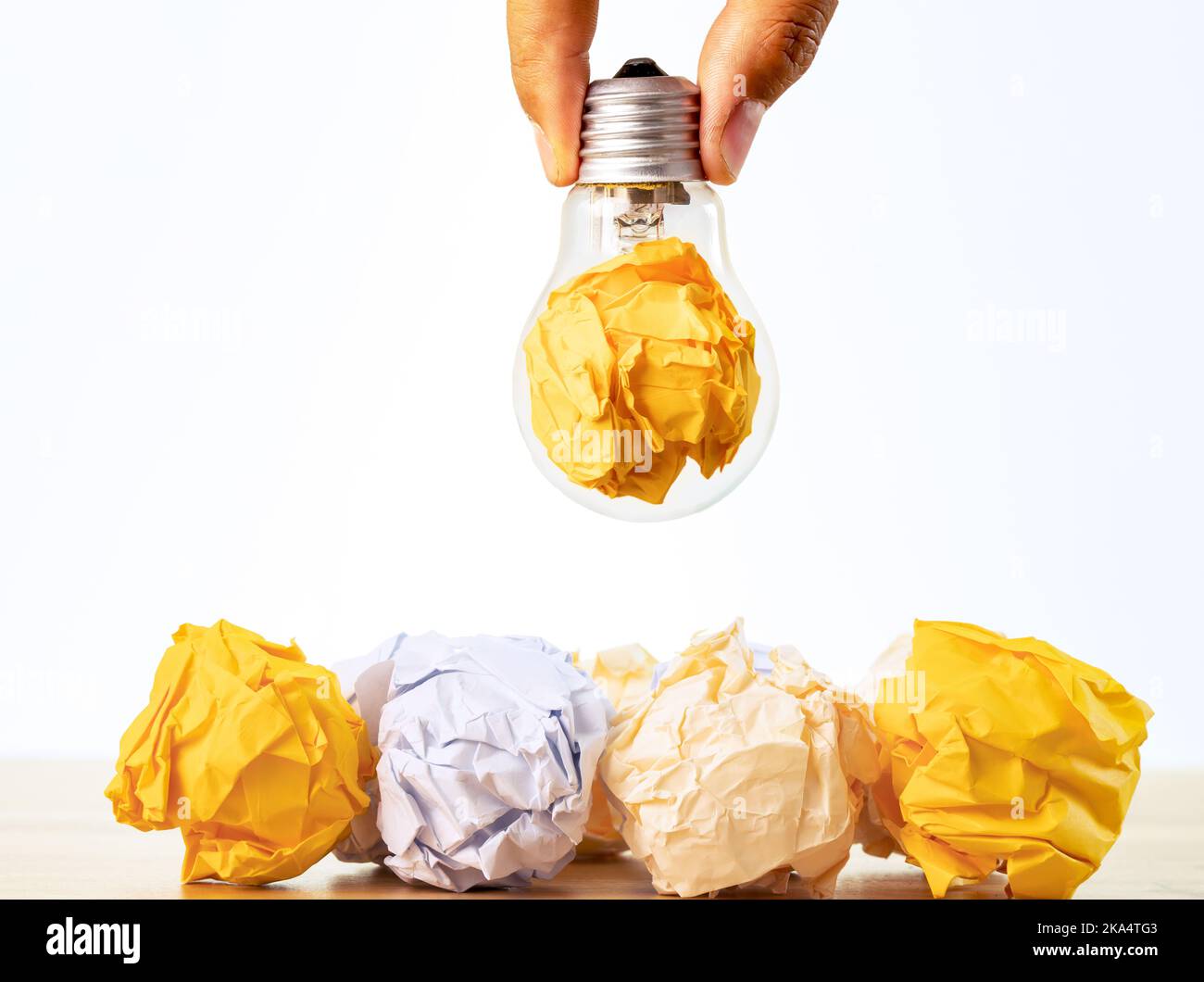 Close up photo of crumbled colorful paper and light bulb in the same frame as a symbol of persistance, perseverance and hardwork. Stock Photo