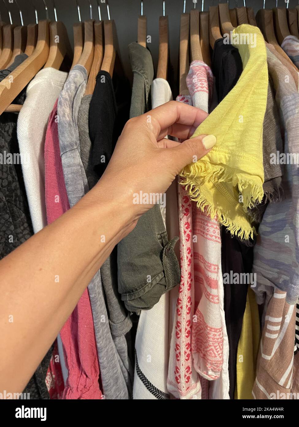 Woman choosing a summer top from a wardrobe Stock Photo