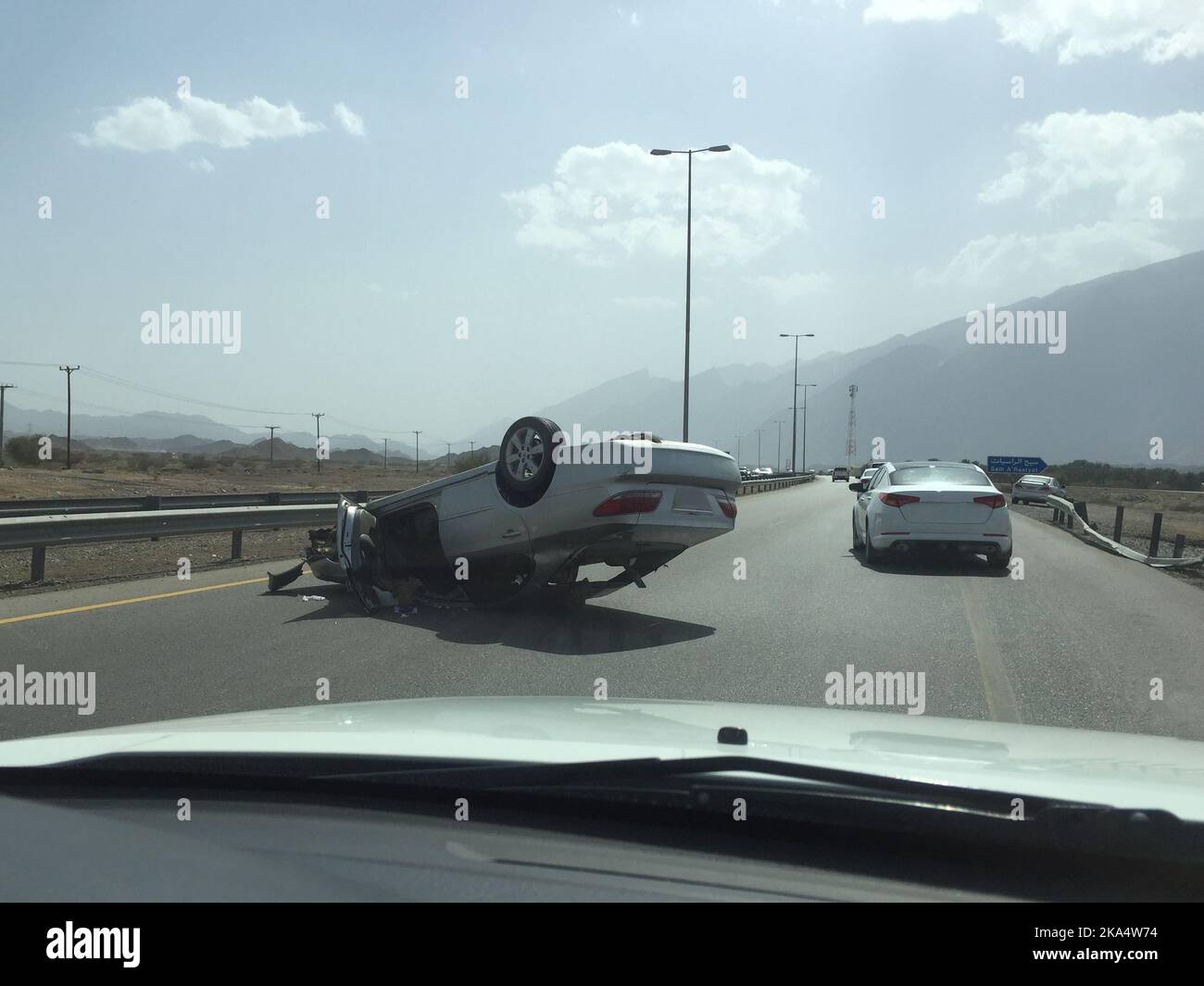 Overturned car on a motorway after a road accident, Oman Stock Photo