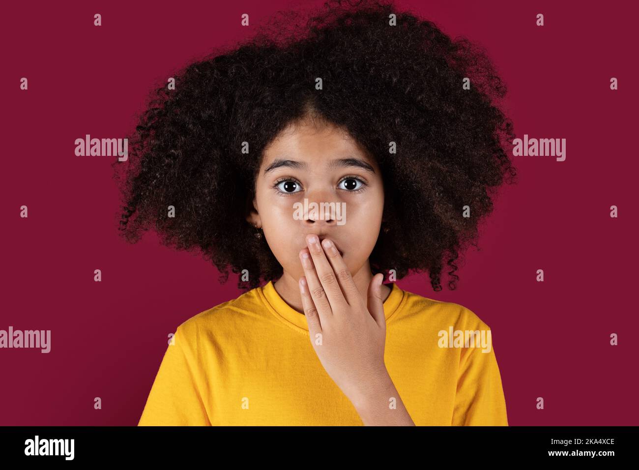 Closeup of shocked african american girl on colorful background Stock Photo