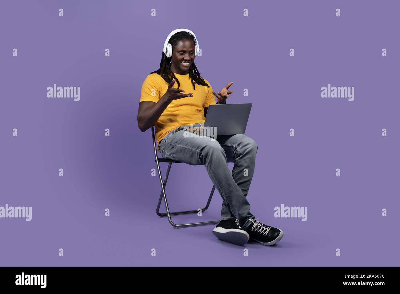 Cheerful black man using computer and headset Stock Photo
