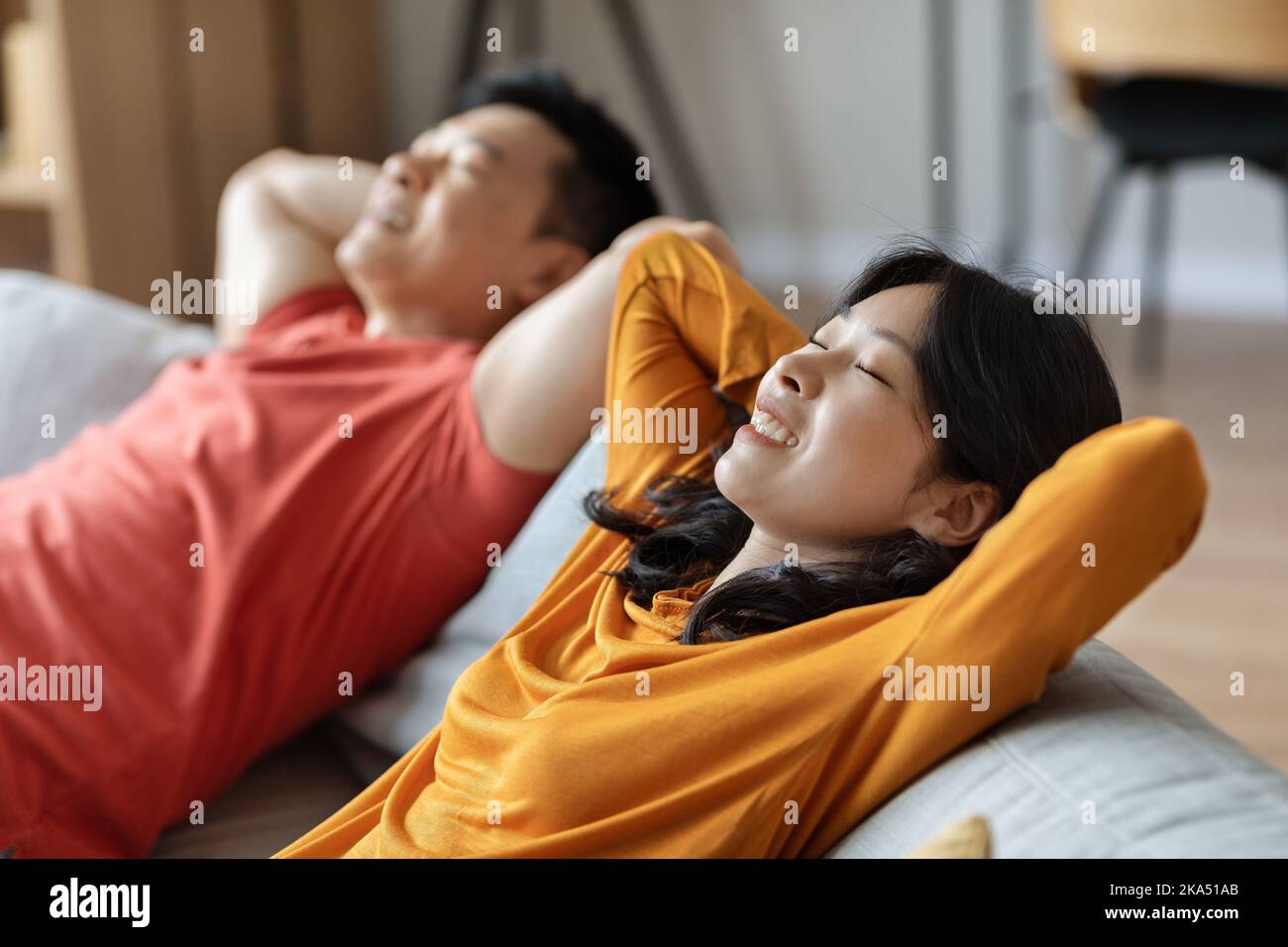 Relaxed asian couple chilling together at home Stock Photo