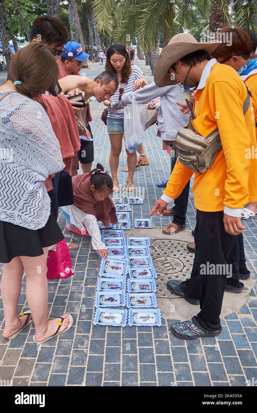Tourists choose souvenir photos after returning from boat trip in Pattaya Thailand Stock Photo