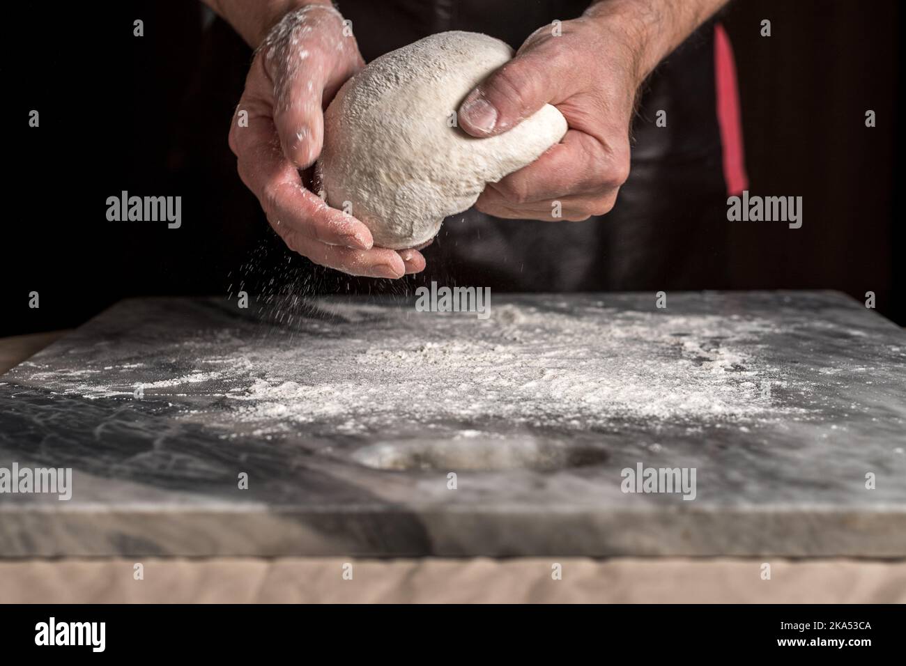 Man preparing pizza, dough on marble table. Stock Photo