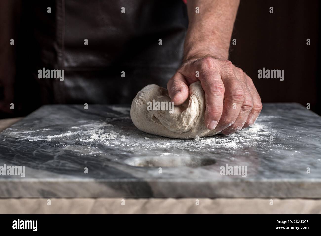 Man preparing pizza, dough on marble table. Stock Photo