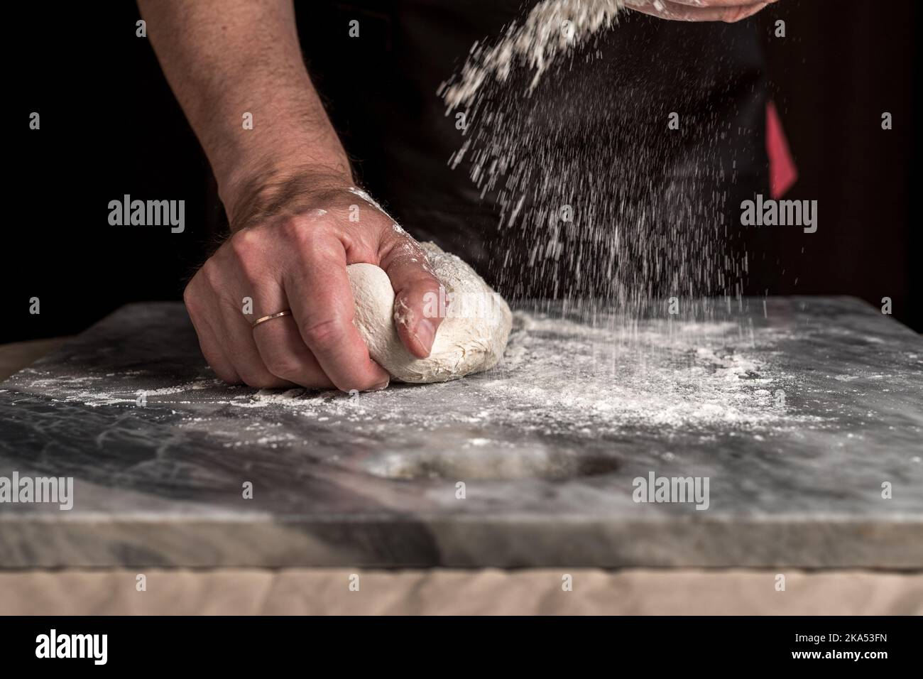 Man preparing pizza, dough on marble table. Stock Photo