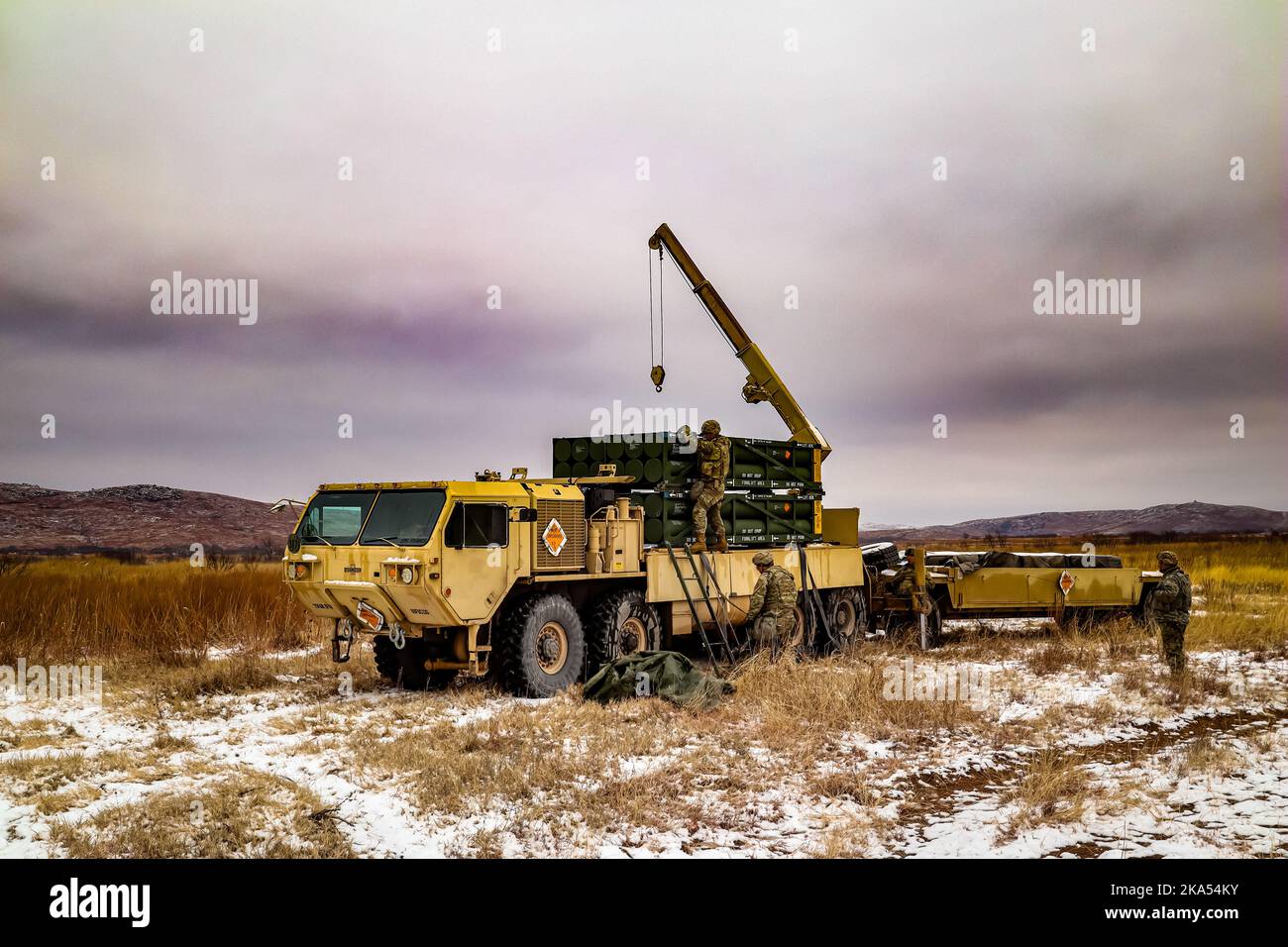 Ammunition Crew picking up the Ammunition for the Multiple Launching Rocket System (MLRS) on a Heavy Expanded Mobility Tactical Truck (HEMTT). Stock Photo