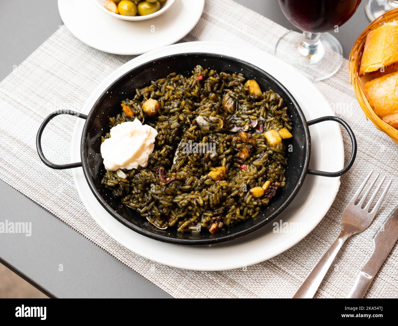 Black paella with cuttlefish ink and seafood in black pan in Spanish