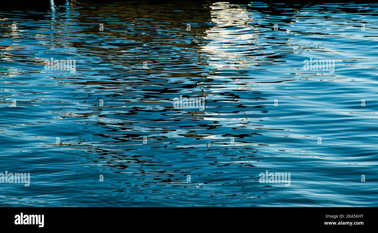 Colors and light reflected in the blue water waves Stock Photo - Alamy