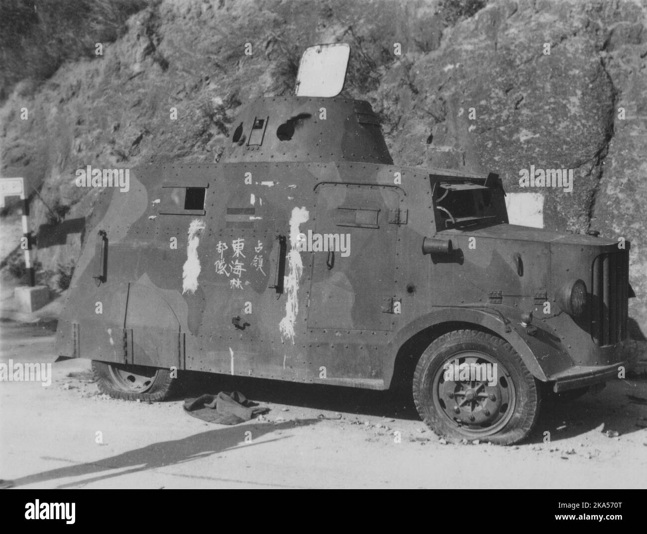 Pacific War, 1941-1945. A battered armored vehicle once belonging to the Hong Kong Volunteer Defense Corps sits abandoned with graffiti denoting its capture by the invading Imperial Japanese Army 230th Infantry Regiment, Battle of Hong Kong, December 1941. Stock Photo