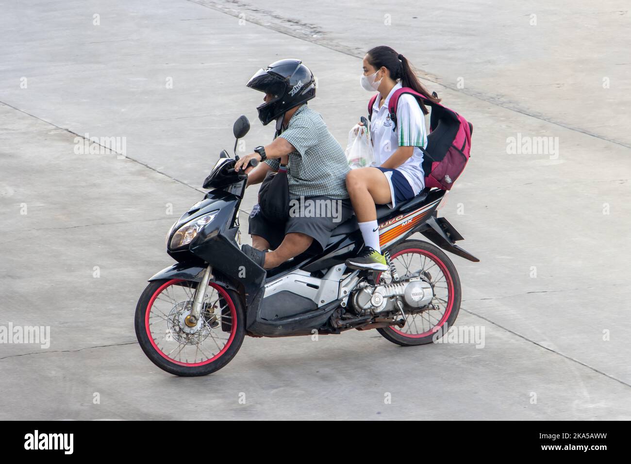 SAMUT PRAKAN, THAILAND, SEP 23 2022,  A short stature man rides a motorcycle with a girl Stock Photo