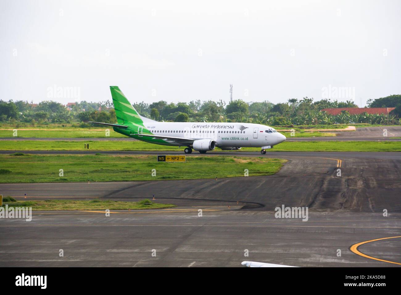 View of Garuda Indonesia Citilink airliner on runway at Juanda International Airport with clouds