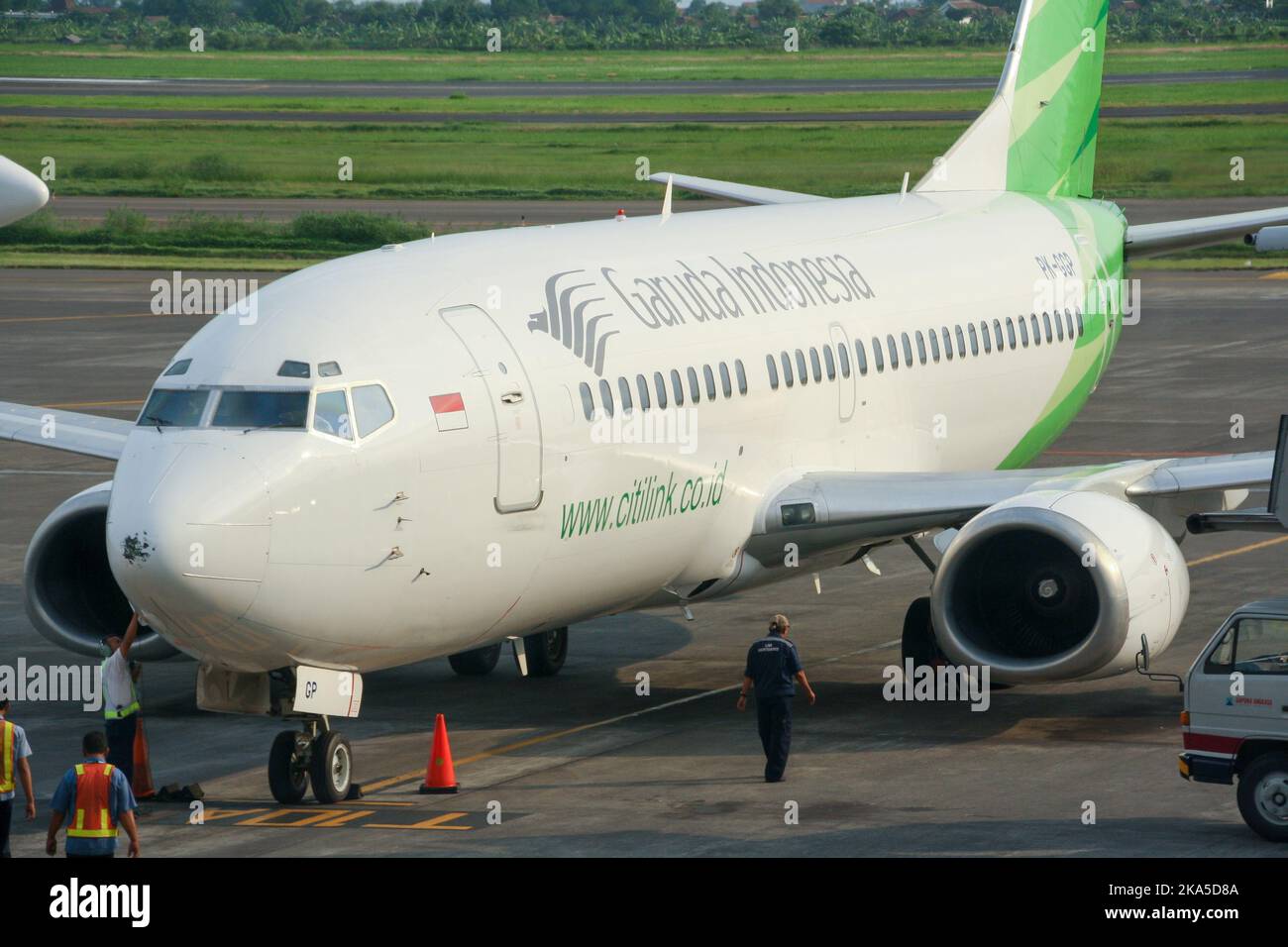 View of Garuda Indonesia low cost carrier Citilink airliner on apron with ground crew at Juanda