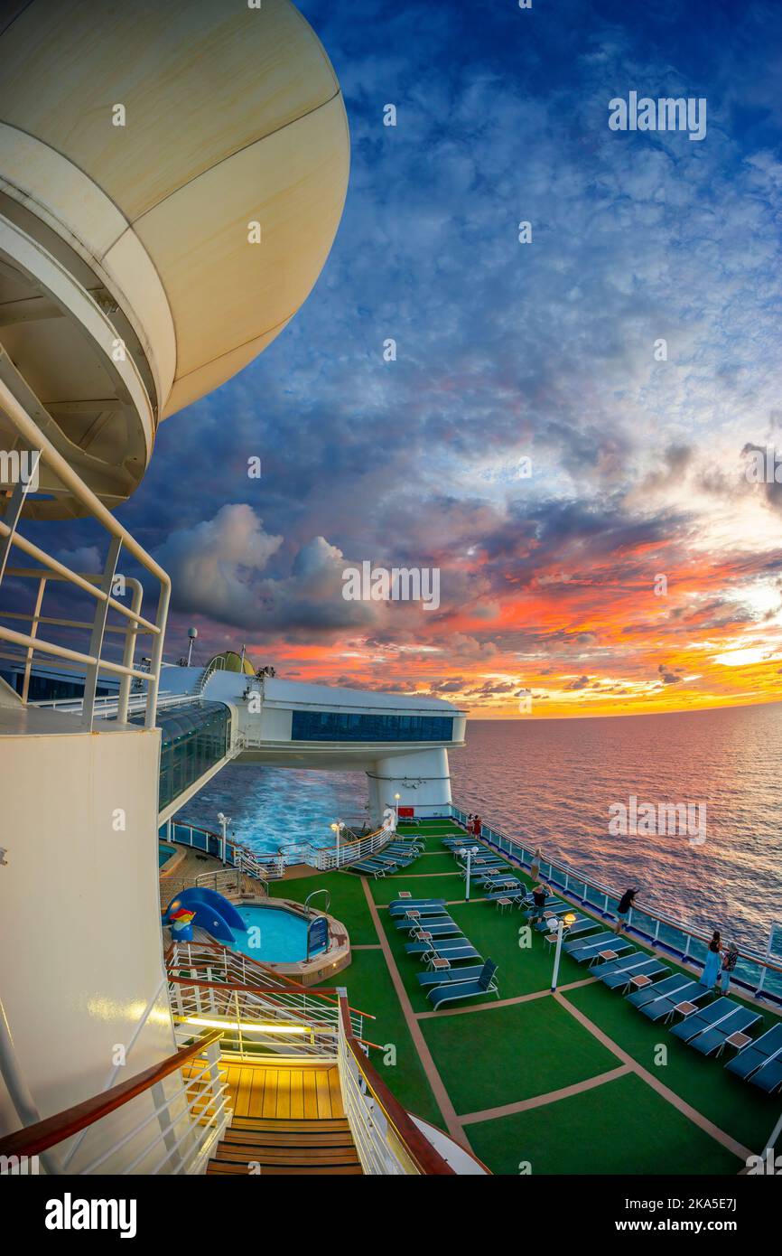 Wide angle view of entertainment deck on cruise liner at sunset with colourful clouds. South Pacific Ocean. Stock Photo