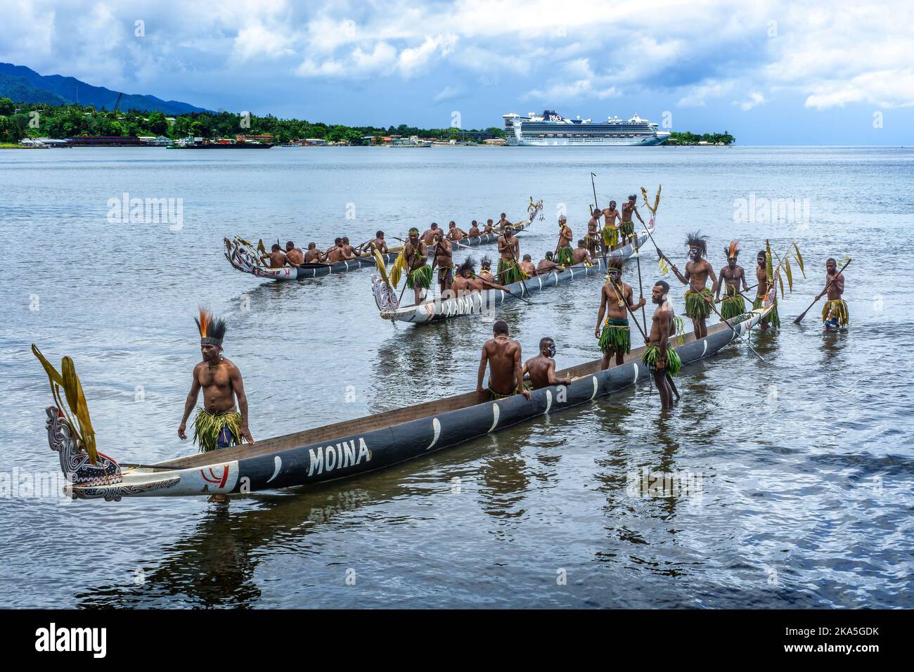 Indigenous paddlers in traditional costume demonstrating paddling