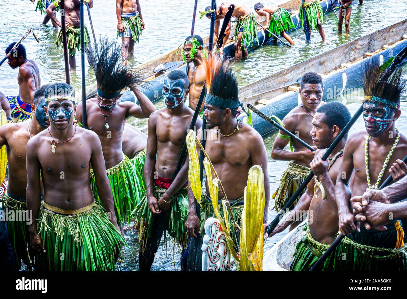 Indigenous paddlers in traditional costume demonstrating paddling