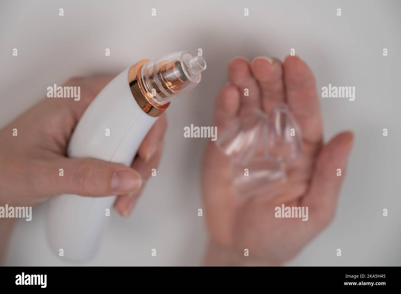 Woman holding a vacuum pore cleaner with different nozzles Stock Photo