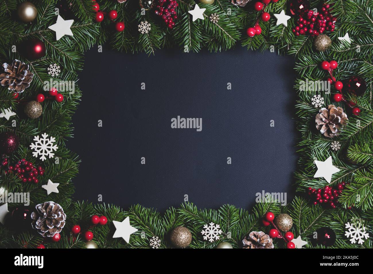 Natural fir Christmas tree border frame with decor on black, copy space ...
