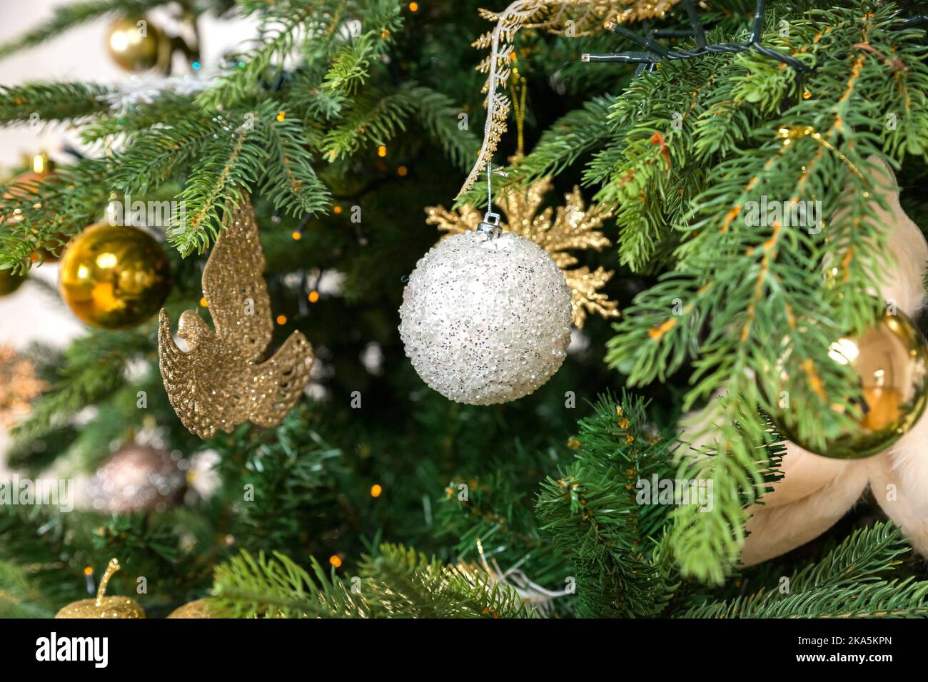 Christmas decoration. white and golden balls hanging on pine branches  Christmas tree, garland and ornaments.celebrate the christmas season with  Stock Photo - Alamy