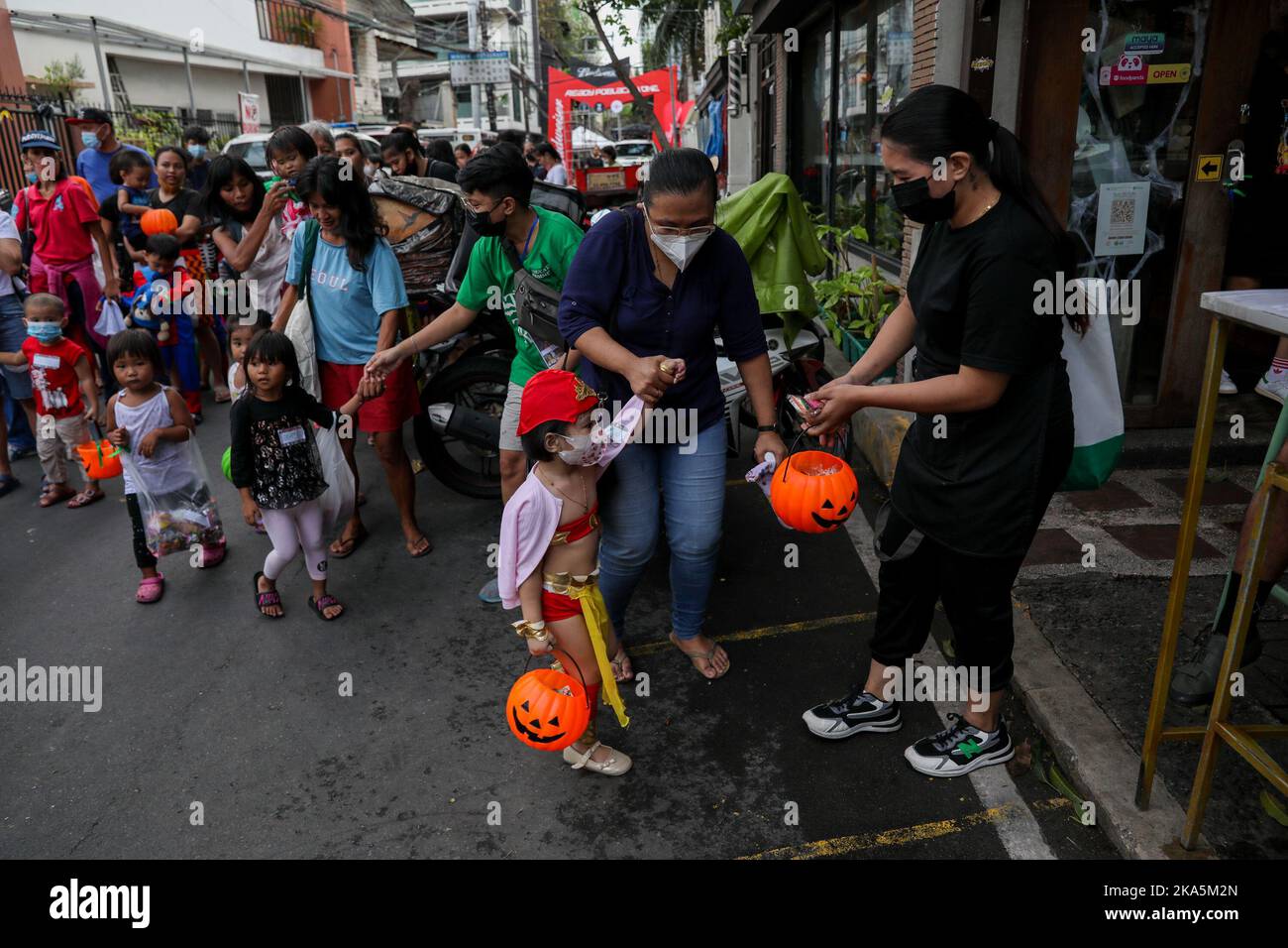 Manila, Philippines. 31st Oct, 2022. Residents give treats to children