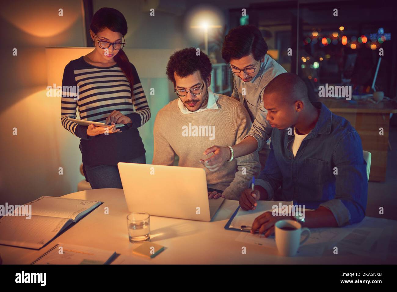 Theyve got the determination to beat their deadlines. a group of designers working late in an office. Stock Photo