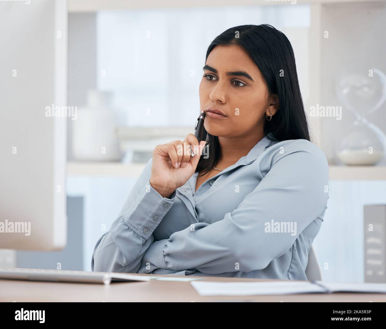 Computer, thinking and idea with a business woman at work alone at a desk in an office alone. Internet, email and planning with a female employee Stock Photo