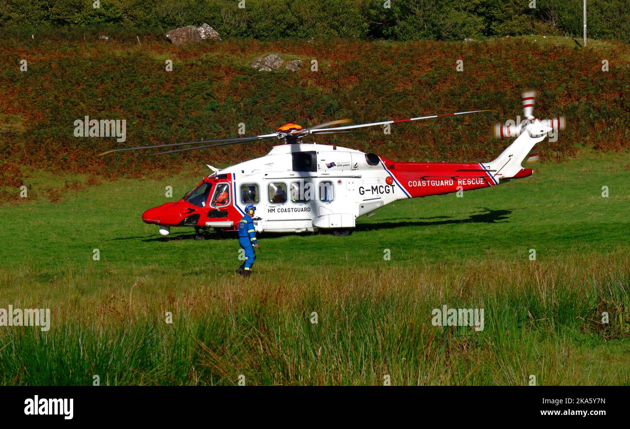 An HM Coastguard AgustaWestland AW189 SAR helicopter landing in a green space north of Ulva Ferry on the Isle of Mull, Argyll and Bute, Scotland. Stock Photo
