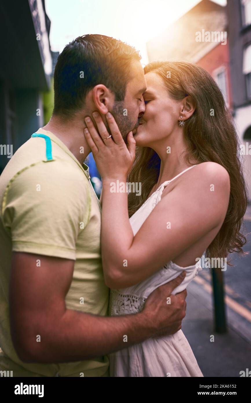 Love is too small a word for what they feel. an affectionate young couple kissing while exploring a foreign city. Stock Photo