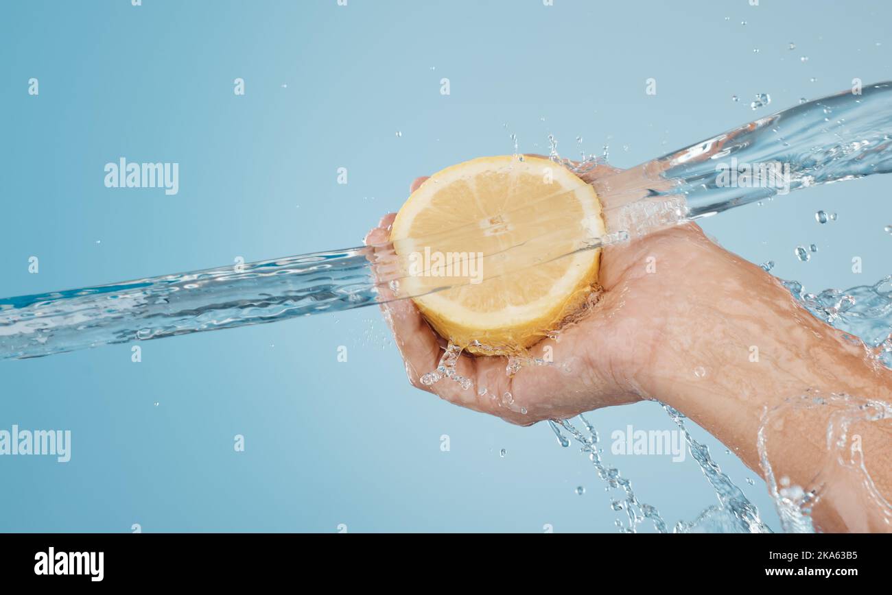 Water, splash and beauty with hands and lemon for health, wellness and hydration. Vitamin c, refreshing or nutrition with citrus fruits and model Stock Photo