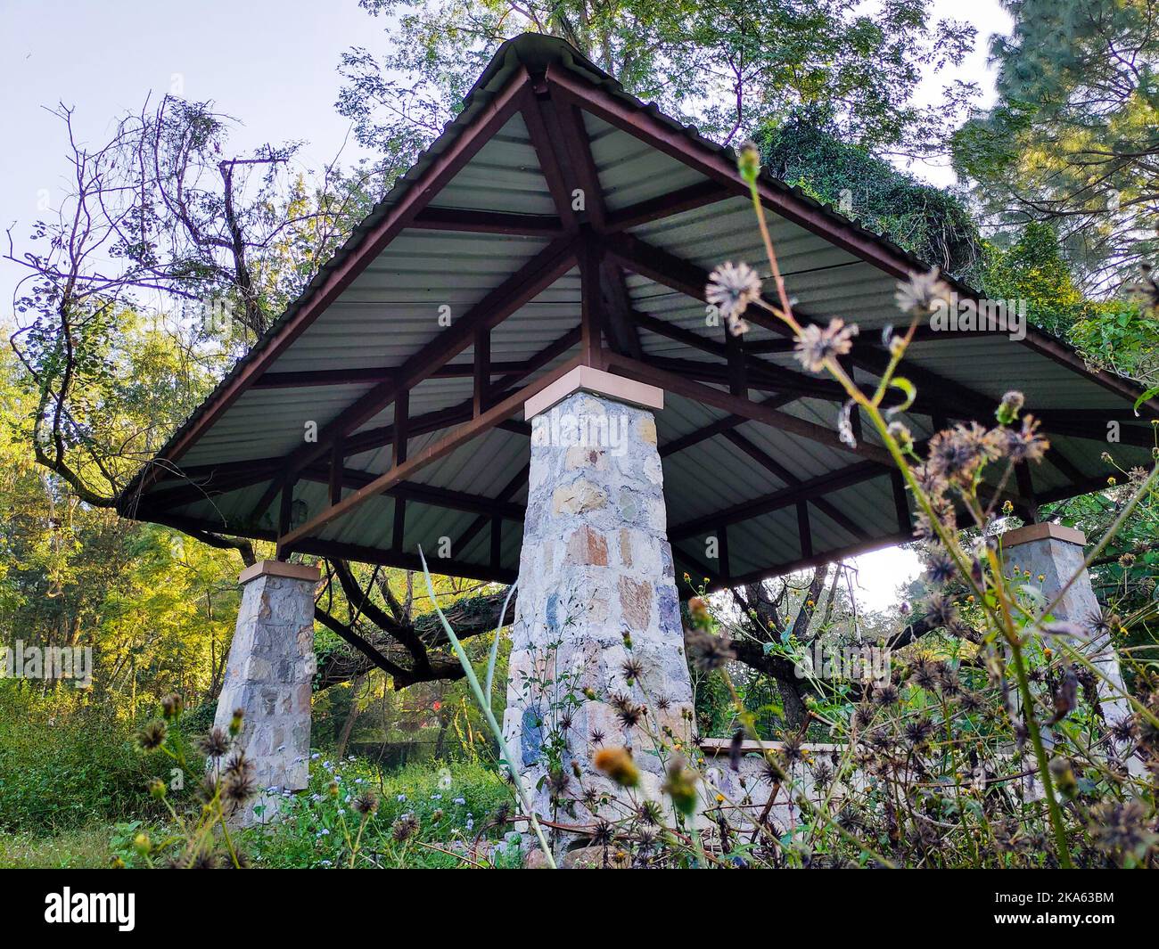 Outdoor patio pergola shade structure made of stones and metal roof top at a garden. Dehradun city India. Stock Photo