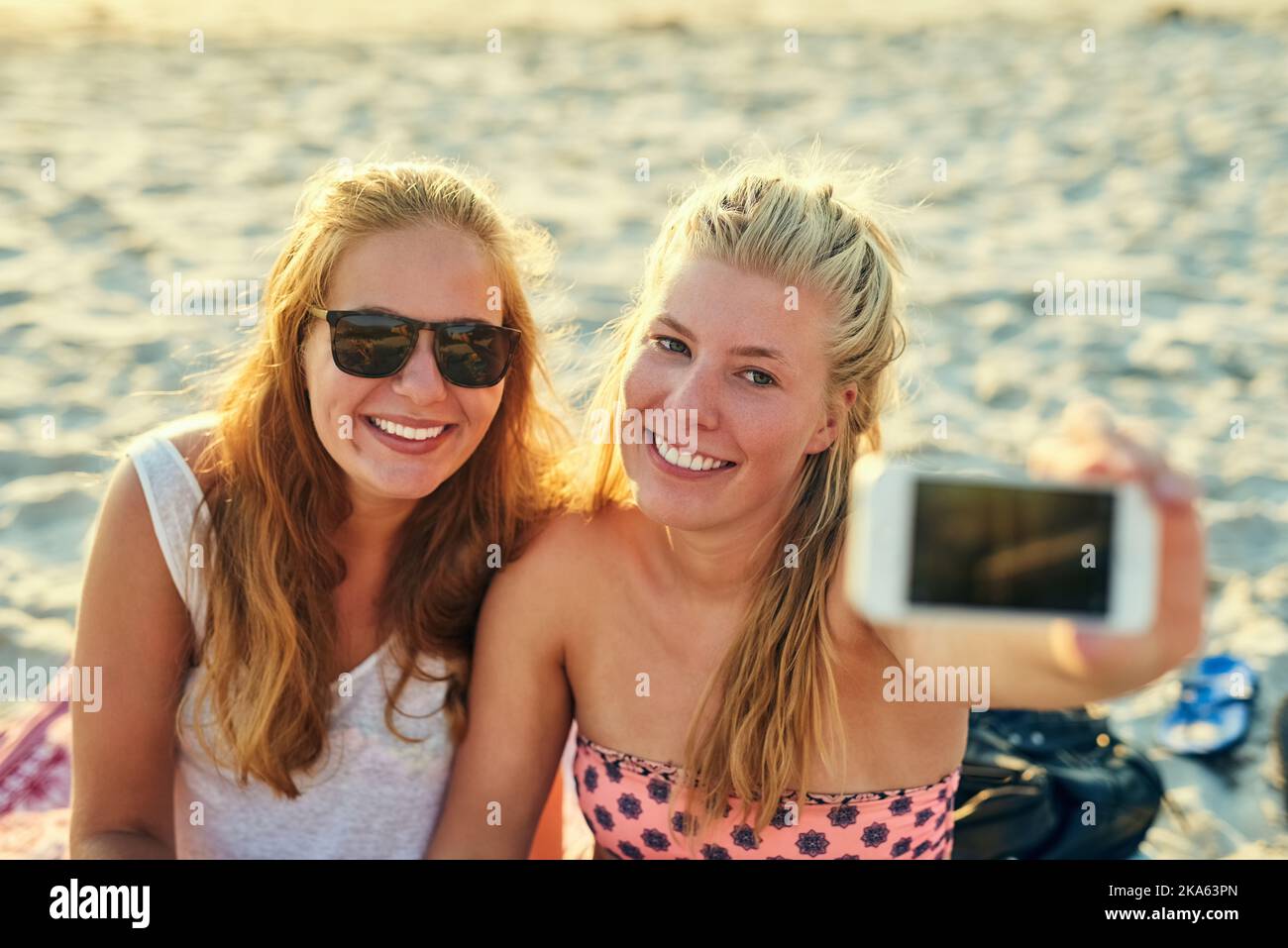 Capture these moments and capture the memories. young female best friends hanging out at the beach. Stock Photo