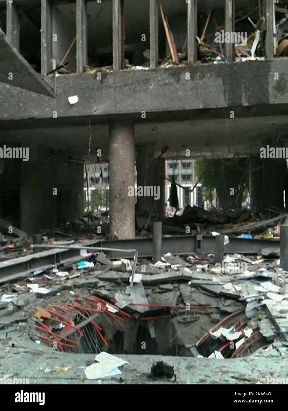 Screen grab from a video showing the crater / hole in the ground under the car with the bomb that exploded outside the high-rise building in the government building on Friday. The picture shows the situation just minutes after the explosion. Stock Photo