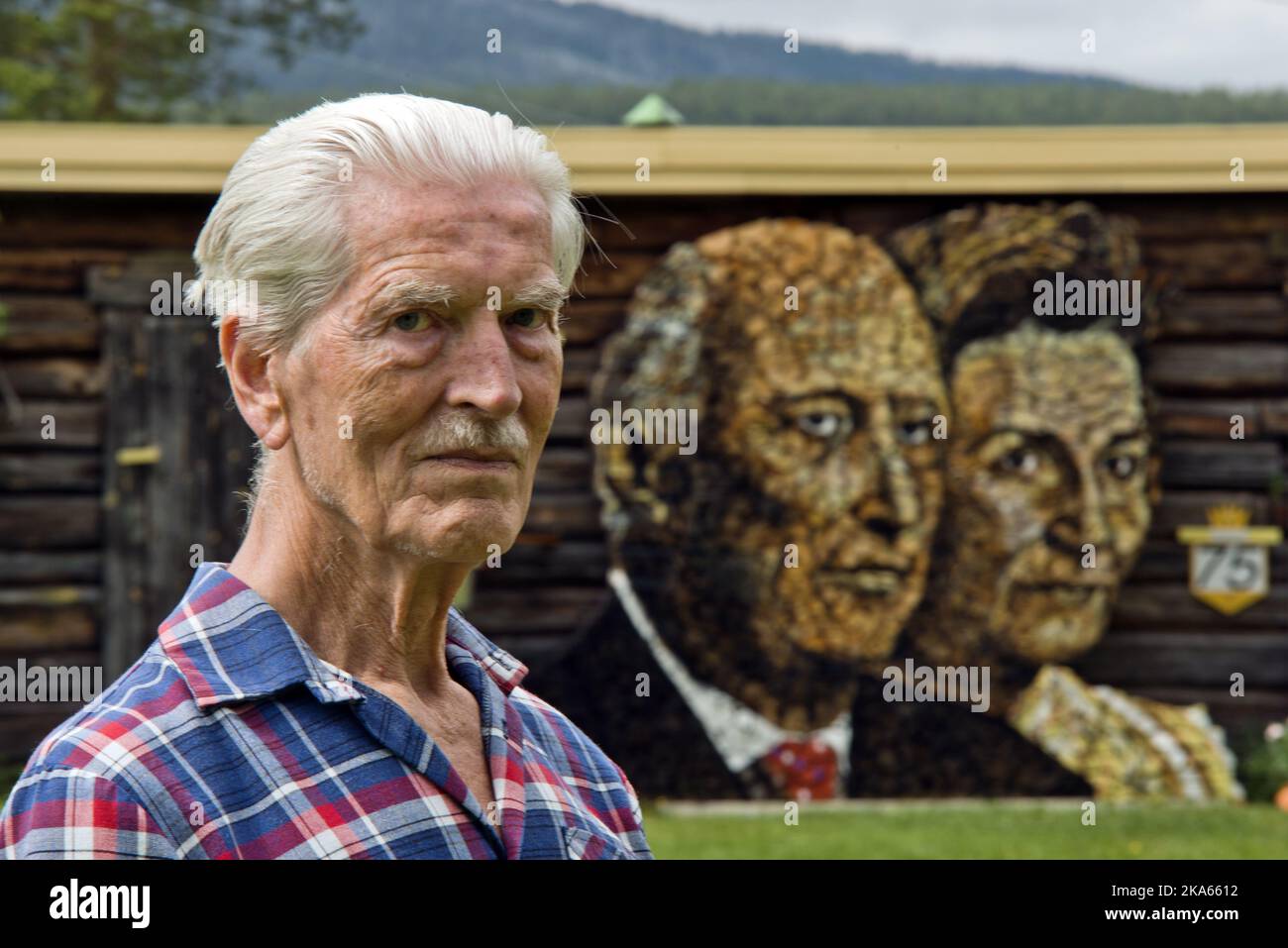 This winter Ole Kristian Kjelling (80) and his wife Zofia will be kept warm by King Harald and Queen Sonja of Norway. A month ago he started the task of stacking firewood into a portrait of the royal couple. It took 6-7 wheelbarrow loads, or 200-300 kilos of birch wood to complete the project. - I have painted everything with ordinary oil paints and been working under a tarpaulin for the last month. It is sculpted and then painted. ItÕs a good thing I have the patience of a horse - the weather has not been on my side Stock Photo