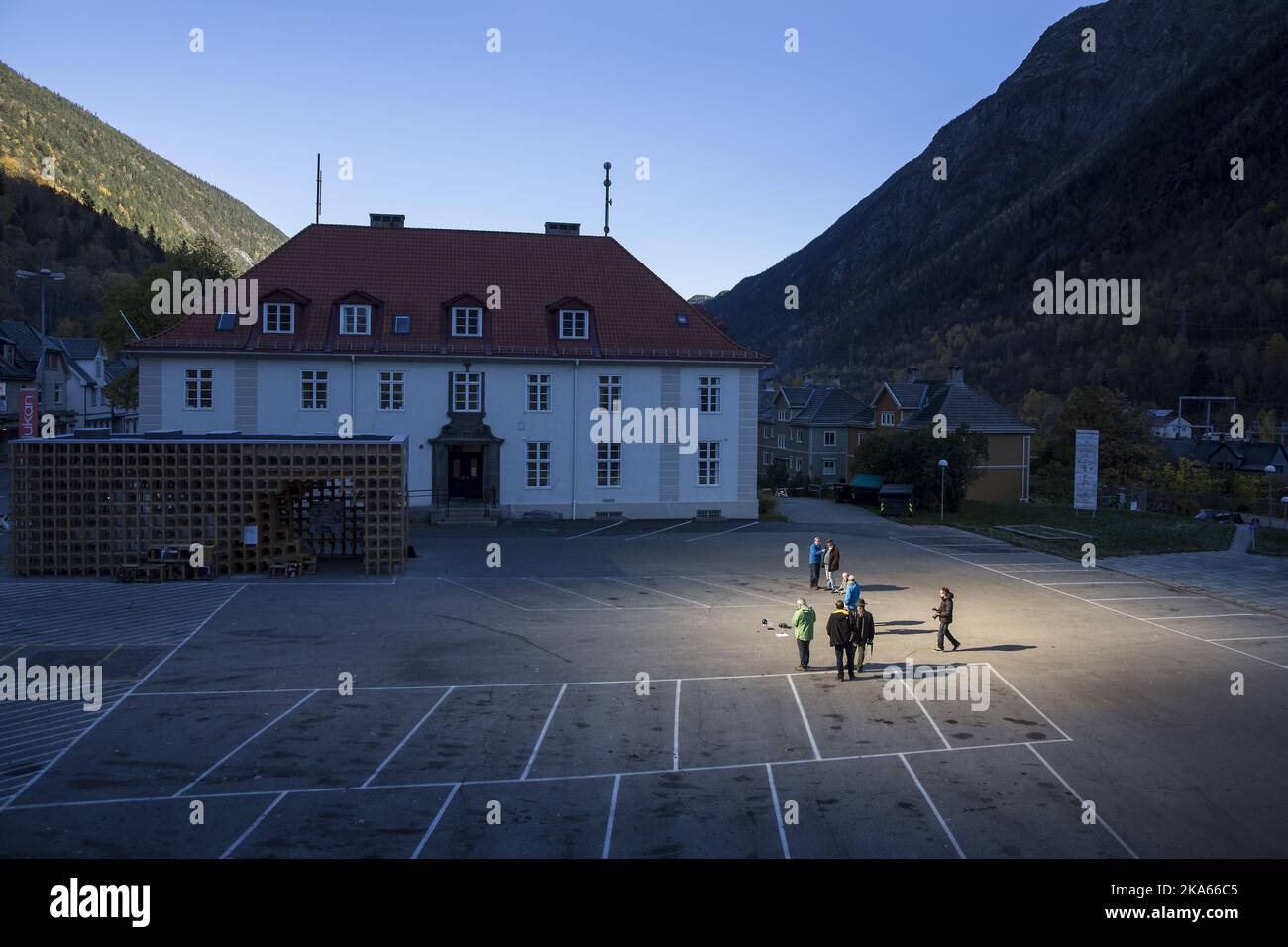 People gathered on a spot in front of the town hall of Rjukan, Norway, October 18, 2013, where sunshine is reflected by three giant mirrors errected on the mountainside above the industrial town. Rjukan, known among other things for its darkness in winter, is located in the bottom of a valley between steep mountains in Telemark County, some 150 km west of Oslo. The idea about mirrors reflecting sunshine to the town in winter was launched 100 years ago and it now becomes a reallity by official opening on October 31st. Stock Photo