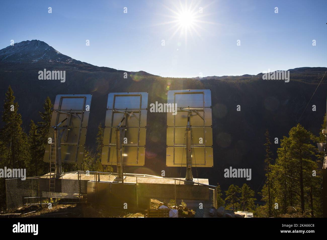 Three giant mirrors errected on the mountainside above the industrial town Rjukan, Norway, reflect sunshine towards the center of the town, October 18, 2013. Rjukan, known among other things for its darkness in winter, is located in the bottom of a valley between steep mountains in Telemark County, some 150 km west of Oslo. The idea about mirrors reflecting sunshine to the town in winter was launched 100 years ago and it now becomes a reallity by official opening on October 31st. Stock Photo
