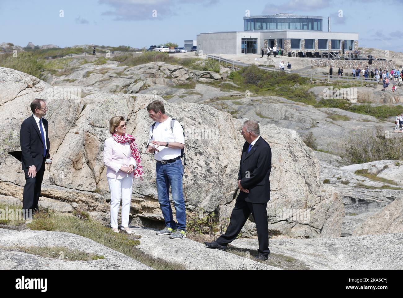 Faerder, Norway 20150627. HM Queen Sonja arrives Faerder National Park at Verdens Ende on Tjoemoe. Amateur geologist Terje Kristiansen talks about the area. Mayr Jan Marthiniussen (left) and County Governor Erling Lae (right) Foto: Terje Bendiksby / NTB scanpix  Stock Photo