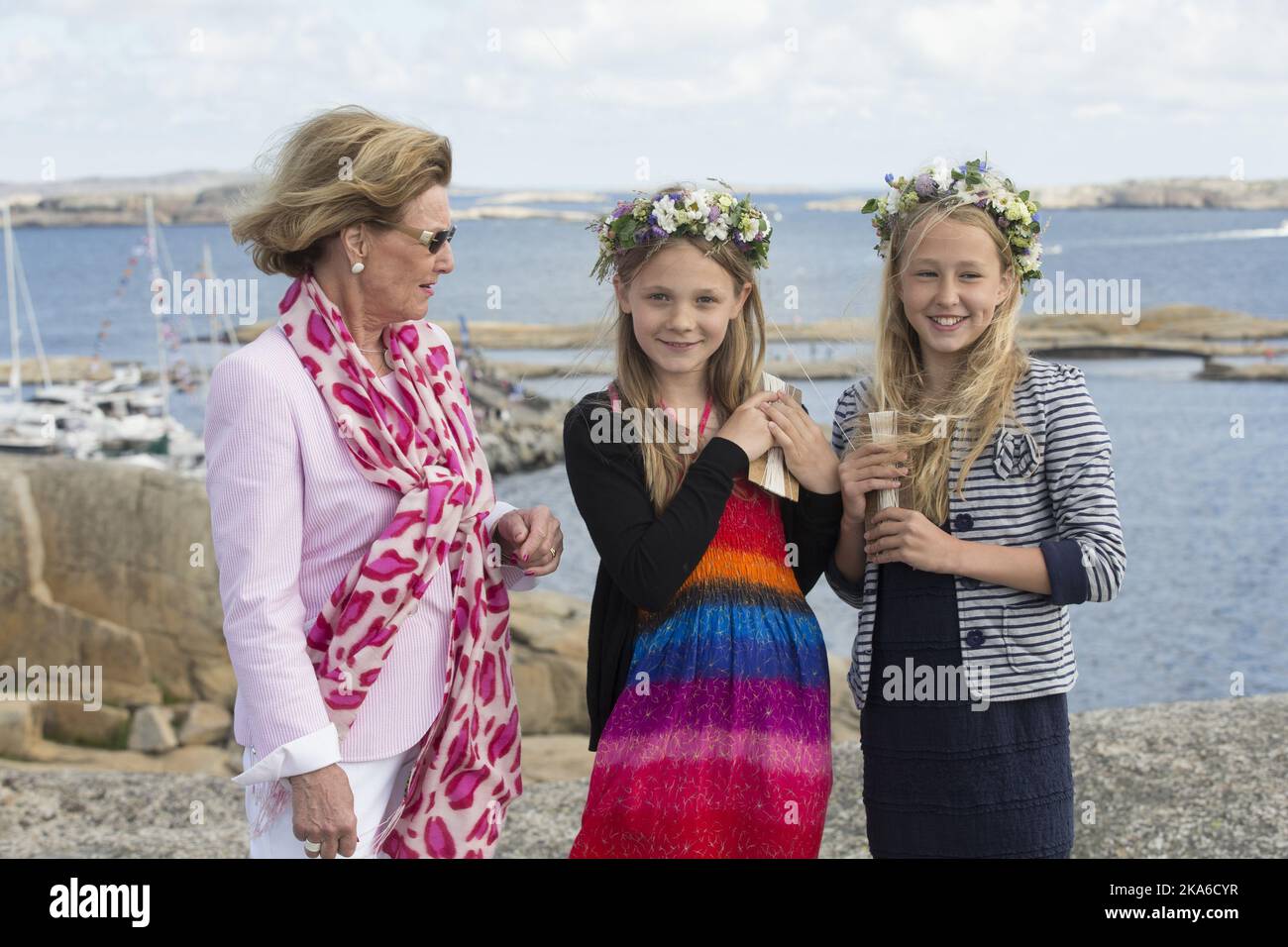 Faerder, Norway 20150627. HM Queen Sonja visits Faerder National Park at Verdens Ende on Tjoemoe. She is welcomed by Anna Almquist and Neele Putz, both are 5th grade students at Lindhoy school. Foto: Terje Bendiksby / NTB scanpix  Stock Photo
