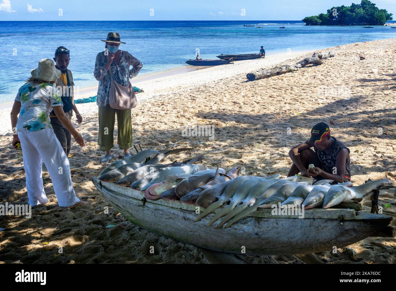 Locals displaying and selling catch of shark on beach, Kiriwina Island, Milne Bay Province